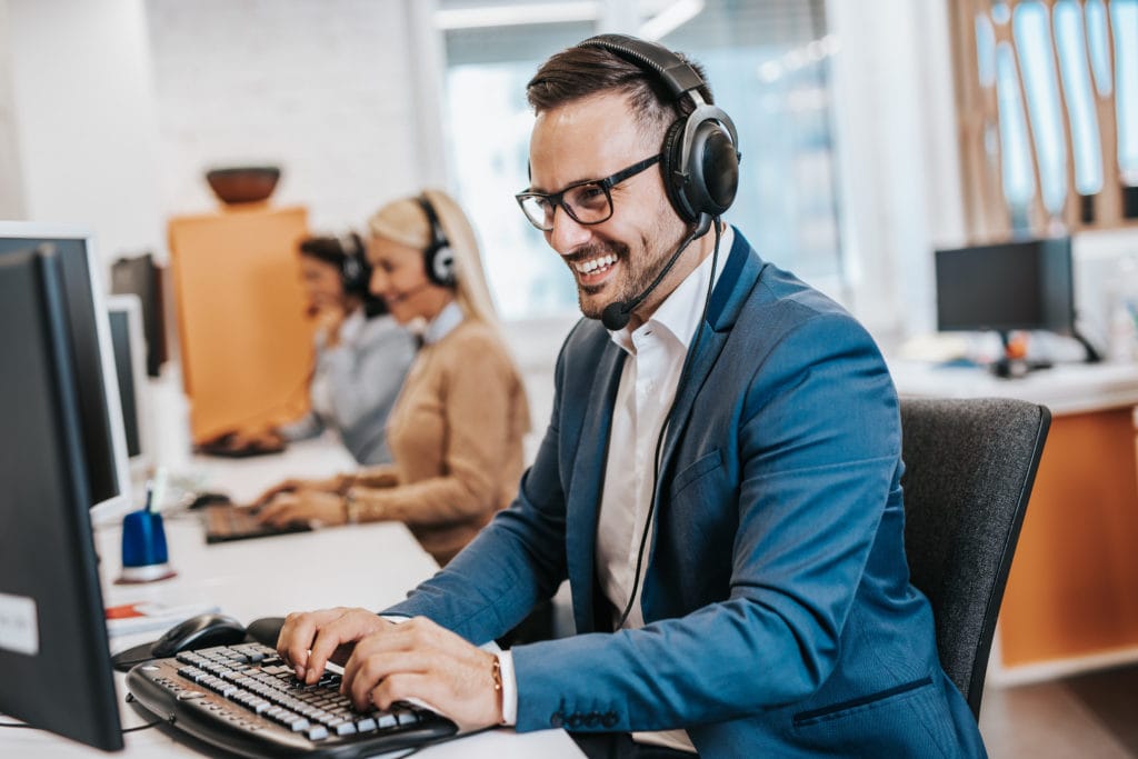 Handsome male customer service agent working in call center office as a sales development specialist