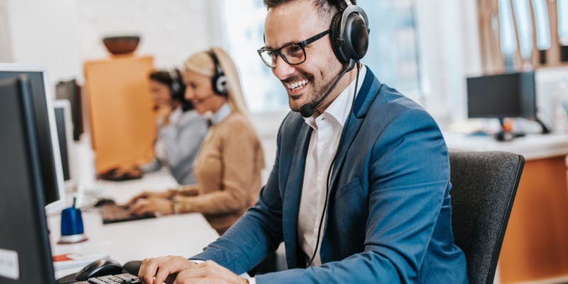 Handsome male customer service agent working in call center office as a sales development specialist