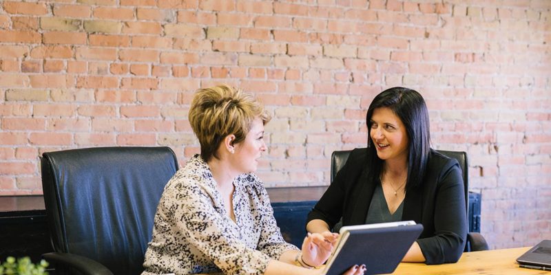 Two women talking at a conference table