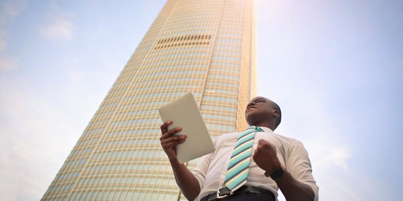 Man holding papers in front of a building