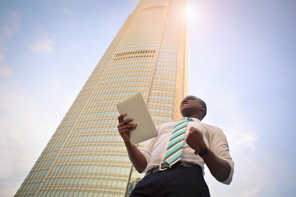 Man holding papers in front of a building
