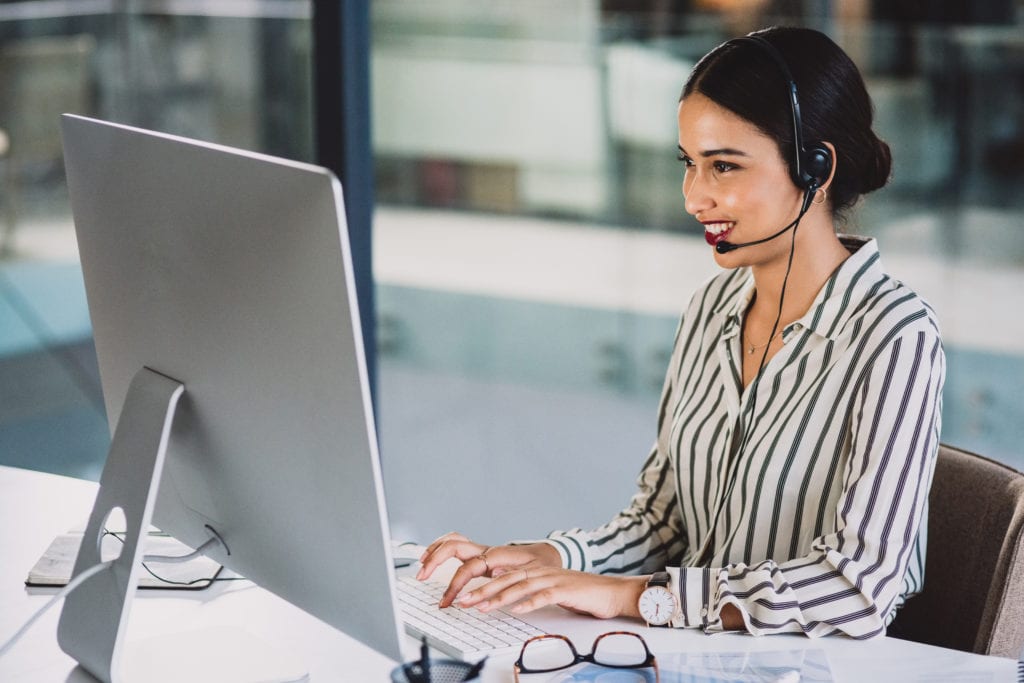 Call center agent on headset and using computer