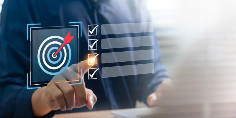 Business professional selecting a sales target checklist on a digital interface, symbolizing B2B sales goals.